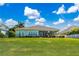 A charming backyard with well-maintained grass, a white picket fence, and the home's exterior at 716 Manns Harbor Dr, Apollo Beach, FL 33572