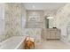 Bright bathroom featuring a soaking tub, glass-enclosed shower, and a stylish vanity at 716 Manns Harbor Dr, Apollo Beach, FL 33572