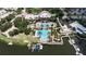 Aerial view of a community pool, featuring multiple swimming areas, lounge seating, and a dock with boats at 716 Manns Harbor Dr, Apollo Beach, FL 33572