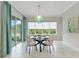 Bright dining area featuring a glass table, statement lighting, sliding glass doors and large windows at 716 Manns Harbor Dr, Apollo Beach, FL 33572