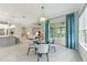 Open-concept dining area with glass table, blue accents, and view into the kitchen and living room at 716 Manns Harbor Dr, Apollo Beach, FL 33572