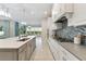 Modern kitchen with white cabinetry, stainless steel appliances, gray countertops and island overlooking the dining area at 716 Manns Harbor Dr, Apollo Beach, FL 33572