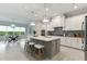 Bright kitchen with white cabinets, gray island, stainless steel appliances, and pendant lights over the breakfast bar at 716 Manns Harbor Dr, Apollo Beach, FL 33572