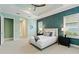 Main bedroom with tray ceiling, accent wall, ceiling fan, and access to a hallway with ensuite bathroom at 716 Manns Harbor Dr, Apollo Beach, FL 33572