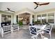 This covered patio features tiled floors, comfortable seating, a ceiling fan, and access to the home's interior at 716 Manns Harbor Dr, Apollo Beach, FL 33572
