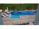 A rendering of a backyard pool with lounge chairs, an umbrella and a small spa at 716 Manns Harbor Dr, Apollo Beach, FL 33572