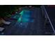 An in-ground pool at night with a spa, blue lights and pavers all around at 716 Manns Harbor Dr, Apollo Beach, FL 33572
