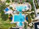 Aerial view of a resort-style pool area with multiple pools, slides, and ample seating surrounded by palm trees at 716 Manns Harbor Dr, Apollo Beach, FL 33572