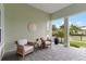 Inviting porch with seating area, decorative sand dollar, and neutral-colored walls at 716 Manns Harbor Dr, Apollo Beach, FL 33572