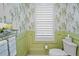 Stylish powder room featuring decorative wallpaper, wainscoting, and elegant fixtures at 716 Manns Harbor Dr, Apollo Beach, FL 33572