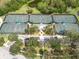 Aerial view of tennis courts with lush landscaping and a central gazebo, creating a recreational oasis at 716 Manns Harbor Dr, Apollo Beach, FL 33572