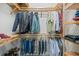 Customized walk-in closet with natural wood, tiered shelving and hanging rods, offering ample space for organizing clothing at 716 Manns Harbor Dr, Apollo Beach, FL 33572