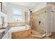 Elegant bathroom with a soaking tub, tiled shower, and natural light at 7207 Forest Mere Dr, Riverview, FL 33578