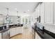 Modern kitchen with stainless steel appliances, granite counters, and an adjacent living area at 7207 Forest Mere Dr, Riverview, FL 33578