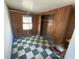 Bedroom with paneled walls, tiled floor, closet, and a window at 7365 Royal Palm Dr, New Port Richey, FL 34652