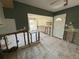 View of gutted living room and kitchen area, with natural light streaming in through the windows at 7366 Royal Palm Dr, New Port Richey, FL 34652