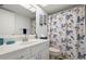 Bathroom with floral shower curtain, white vanity, and plenty of natural light at 8141 Aquila St # 342, Port Richey, FL 34668