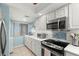 Well-lit kitchen with white cabinets, stainless steel appliances, and view from window at 8141 Aquila St # 342, Port Richey, FL 34668