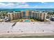 Aerial view of beachfront condos and a large swimming pool on a sunny day at 880 Mandalay Ave # N710, Clearwater Beach, FL 33767