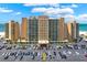 Exterior view of a condo complex with a large parking lot and palm trees at 880 Mandalay Ave # N710, Clearwater Beach, FL 33767