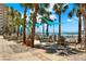 Outdoor pool patio area with seating, palm trees, and shade sails overlooking the ocean at 880 Mandalay Ave # N710, Clearwater Beach, FL 33767