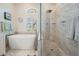 Bright bathroom featuring a soaking tub, glass shower, and white vanity with a glass countertop at 10510 Castleford Way, Tampa, FL 33626