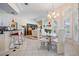 Bright dining area with chandelier, white chairs and bar seating looking into the living room at 10510 Castleford Way, Tampa, FL 33626