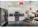 Modern kitchen featuring white cabinets, black countertops, stainless steel appliances, and an island with bar seating at 10510 Castleford Way, Tampa, FL 33626