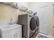 Laundry room with modern washer and dryer, utility sink, and storage space at 10510 Castleford Way, Tampa, FL 33626