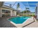 Beautiful screened-in pool surrounded by lush landscaping and a brick patio at 10510 Castleford Way, Tampa, FL 33626