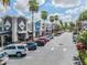View of a shopping center with palm trees, parking and retail stores under a sunny sky at 10510 Castleford Way, Tampa, FL 33626