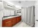 Bathroom featuring a double vanity, granite countertops, wood cabinets, and a shower at 11208 Leland Groves Dr, Riverview, FL 33579