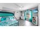 Bright bedroom featuring a bunk bed, wood-style flooring, and a window with colorful curtains at 11208 Leland Groves Dr, Riverview, FL 33579