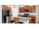 Well-lit kitchen with an island, bar-style seating, granite countertops, and wood cabinetry at 11208 Leland Groves Dr, Riverview, FL 33579