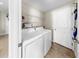 Functional laundry room equipped with a washer, dryer, and shelving for storage at 11208 Leland Groves Dr, Riverview, FL 33579