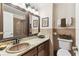 Bathroom featuring dark wood vanity, granite countertop, and decorative mirror at 11383 Pickford St, Spring Hill, FL 34609