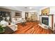 Open-concept living and dining area with hardwood floors and a cozy fireplace at 11383 Pickford St, Spring Hill, FL 34609