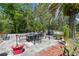 Outdoor patio with dining table, grill, and a neatly arranged garden at 11383 Pickford St, Spring Hill, FL 34609