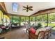 Bright sunroom featuring a skylight, ceiling fan, and comfortable wicker furniture at 11383 Pickford St, Spring Hill, FL 34609