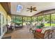 Bright sunroom featuring a skylight, ceiling fan, and comfortable wicker furniture at 11383 Pickford St, Spring Hill, FL 34609