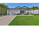 Charming single-story home features a well-manicured lawn, lush landscaping, and a two-car garage at 11407 Leland Groves Dr, Riverview, FL 33579