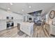 Bright, open-concept kitchen with white cabinetry, stainless steel appliances, large island, and modern lighting at 11407 Leland Groves Dr, Riverview, FL 33579