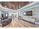 Inviting living room with modern furniture and a decorative wall and coffered ceiling with wood paneling at 11407 Leland Groves Dr, Riverview, FL 33579
