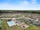 Aerial view of a community pool, clubhouse, parking lot, and playground, showcasing neighborhood amenities at 11530 Adam Lee Way, Dade City, FL 33525