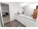 Bright bathroom with vinyl floors, dual vanity, and a view into the bedroom at 11530 Adam Lee Way, Dade City, FL 33525