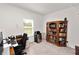 Well-lit home office with a large bookcase, a work desk, and a mini refrigerator at 11530 Adam Lee Way, Dade City, FL 33525