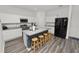 Bright kitchen featuring white cabinets, granite countertops, stainless steel appliances, and a central island with seating at 11530 Adam Lee Way, Dade City, FL 33525