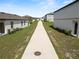 A concrete sidewalk between homes with yards, leading to the neighborhood's layout and outdoor spaces at 11530 Adam Lee Way, Dade City, FL 33525