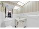 Clean bathroom featuring a single sink vanity, large mirror, and neutral tiling and decor at 1270 Gulf Blvd # 1904, Clearwater Beach, FL 33767
