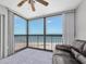 Bright living room with floor-to-ceiling windows providing stunning ocean views, fan, and comfortable furnishings at 1270 Gulf Blvd # 1904, Clearwater Beach, FL 33767